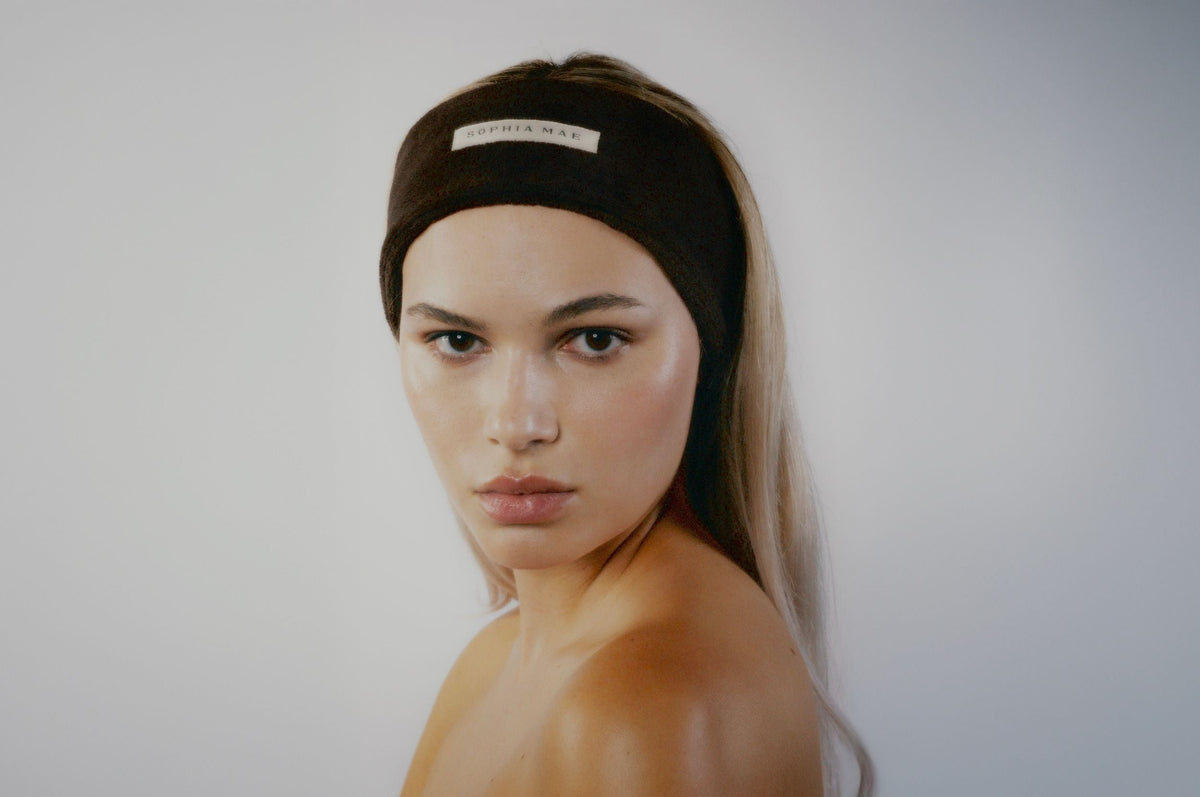 Model wearing a dark brown SOPHIA MAE headband with a subtle logo.