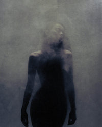 Atmospheric portrait for SOPHIA MAE For A Reason Eau de Parfum, featuring a softly blurred silhouette in a dark, smoky setting that reflects the fragrance’s warm, mysterious mood.