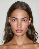 Model wearing SOPHIA MAE Lip Glaze in Soft Pink, with a sheer rosy tint and glossy finish that enhances the natural lip colour.