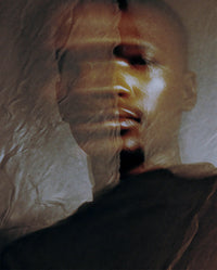 Atmospheric close-up portrait for SOPHIA MAE For A Reason Eau de Parfum, with layered shadows and translucent textures creating a warm, intimate and mysterious mood. Formerly known as AURA. 