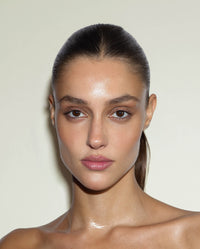 Model with a sleek, pulled-back hairstyle and smooth, polished finish, showcasing the hold and control of SOPHIA MAE Hairspray.