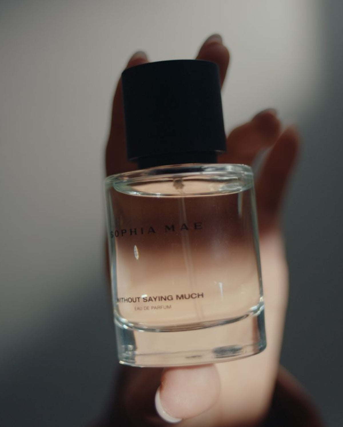 Model holds Without Saying Much eau de parfum SOPHIA MAE. 
