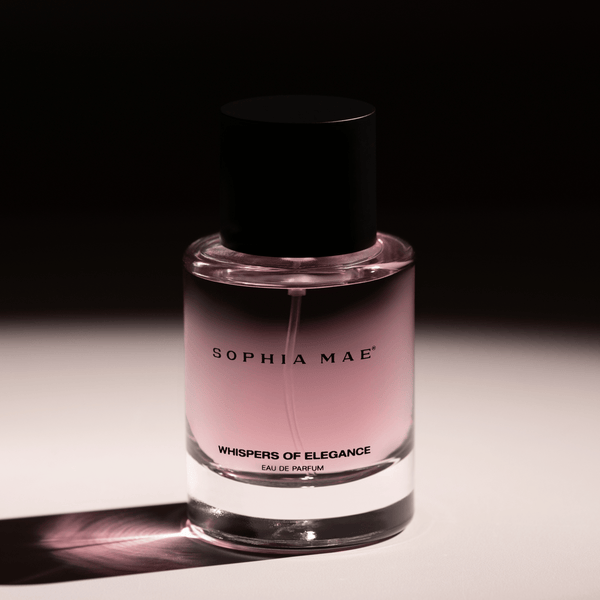 SOPHIA MAE Whispers of Elegance eau de parfum bottle with soft pink fragrance against a dark, elegant background.