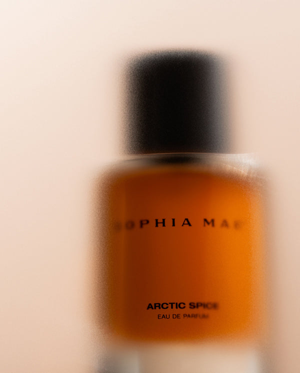 SOPHIA MAE Arctic Spice eau de parfum bottle softly blurred against a warm neutral background.