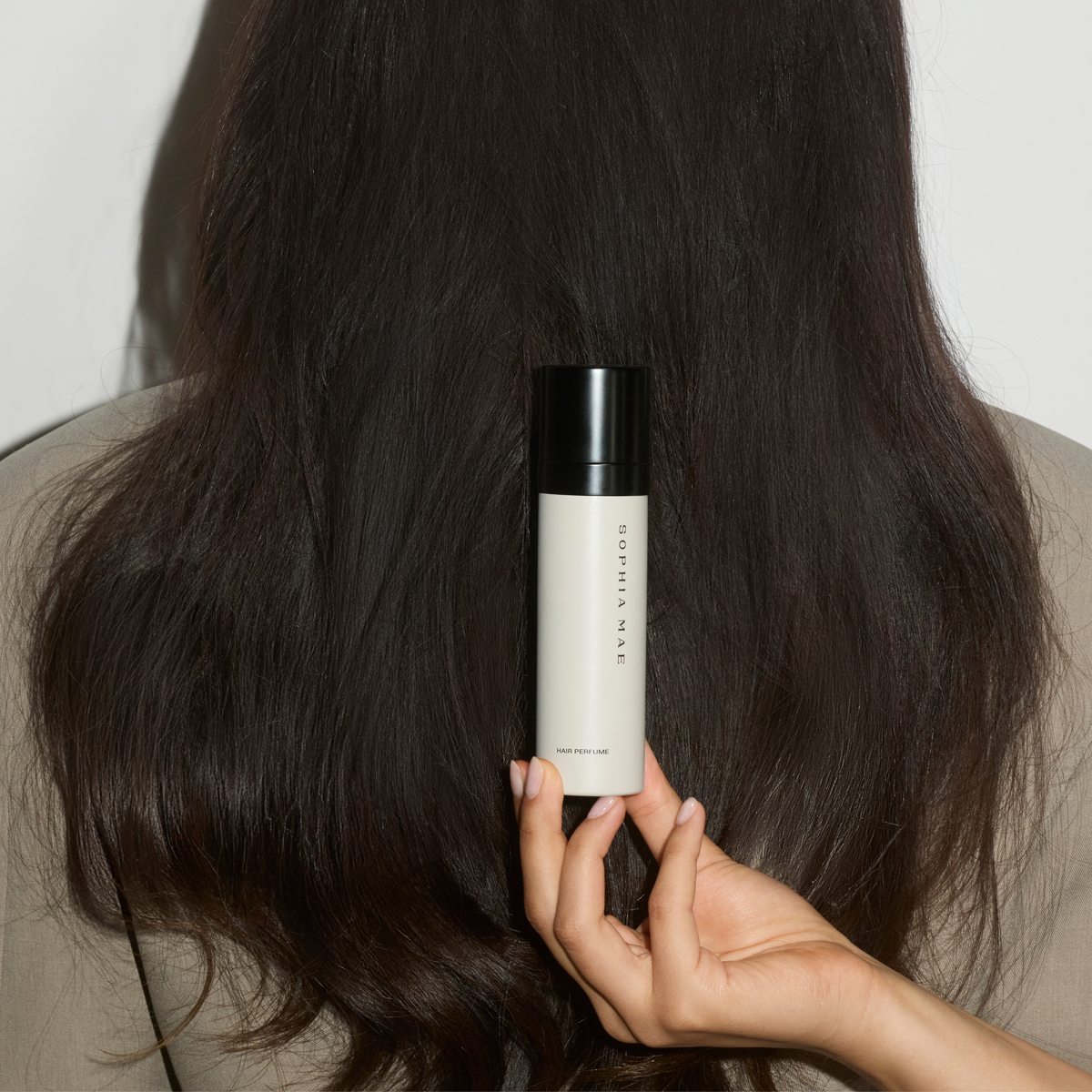 SOPHIA MAE For a Reason Hair Perfume displayed against long, dark hair.