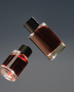 Two SOPHIA MAE Mystic Escape eau de parfum bottles floating against a dark grey background.