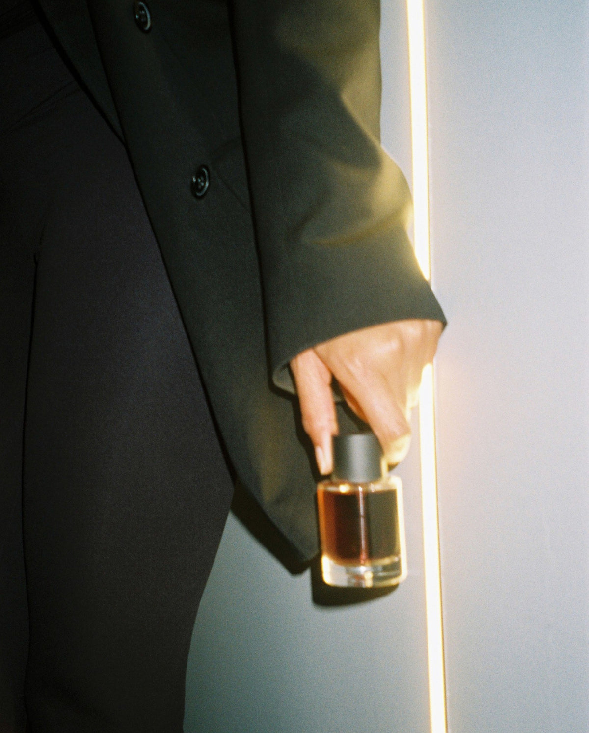 SOPHIA MAE Mystic Escape Eau de Parfum held in hand, illuminated by warm golden light.