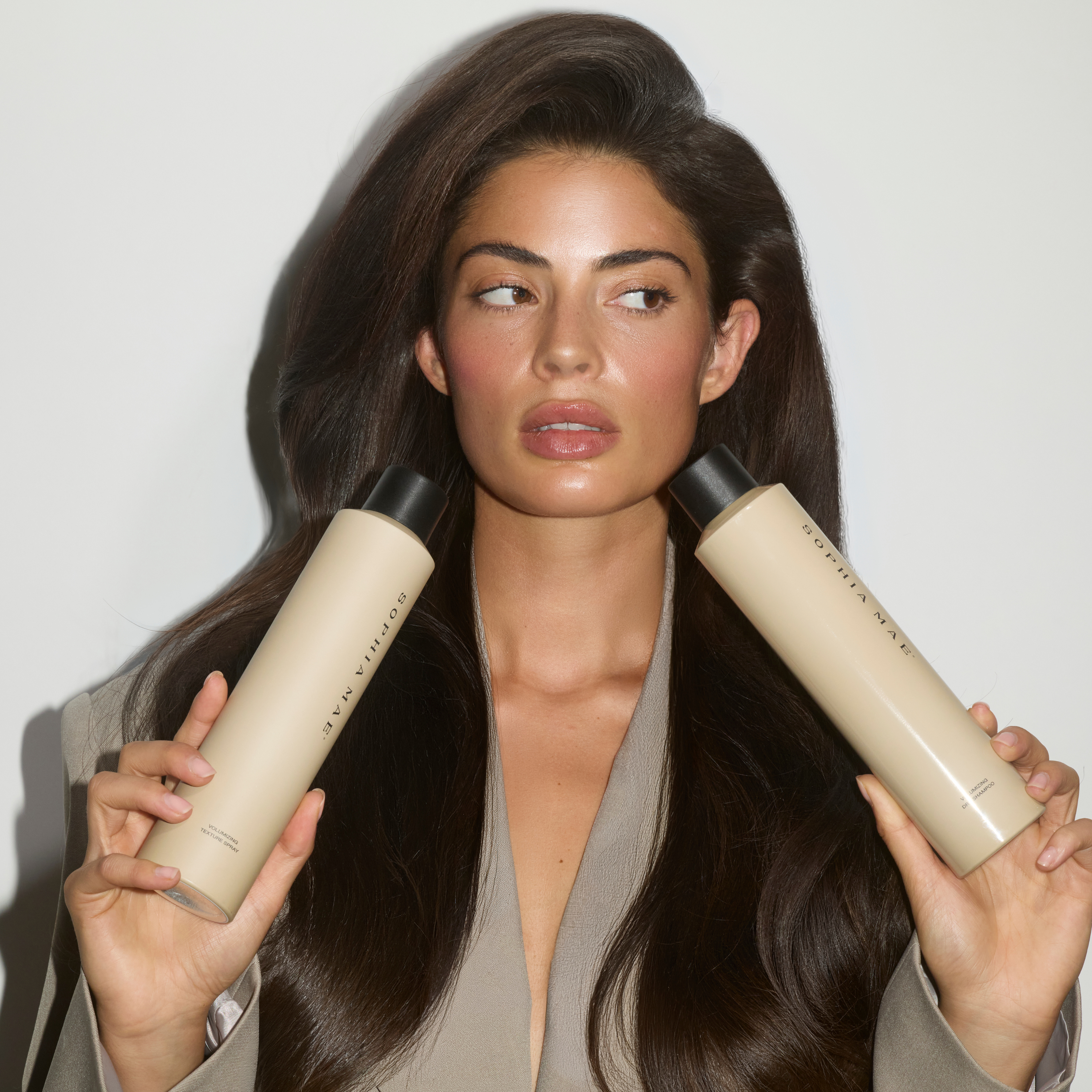 Woman holding SOPHIA MAE Volumizing Dry Shampoo.