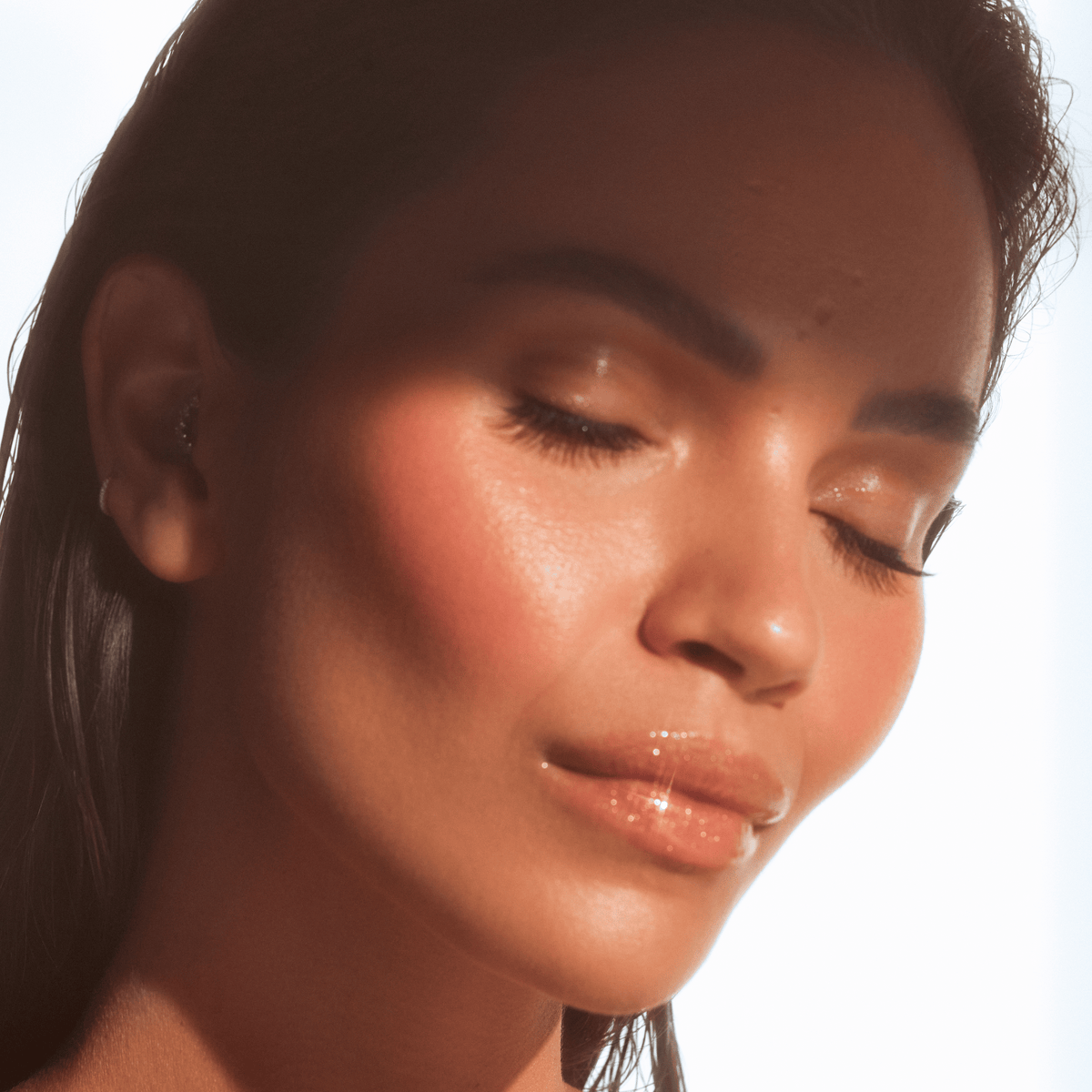 Close-up of Monica Geuze featuring glossy lips with a sheer wash of warm golden shimmer.