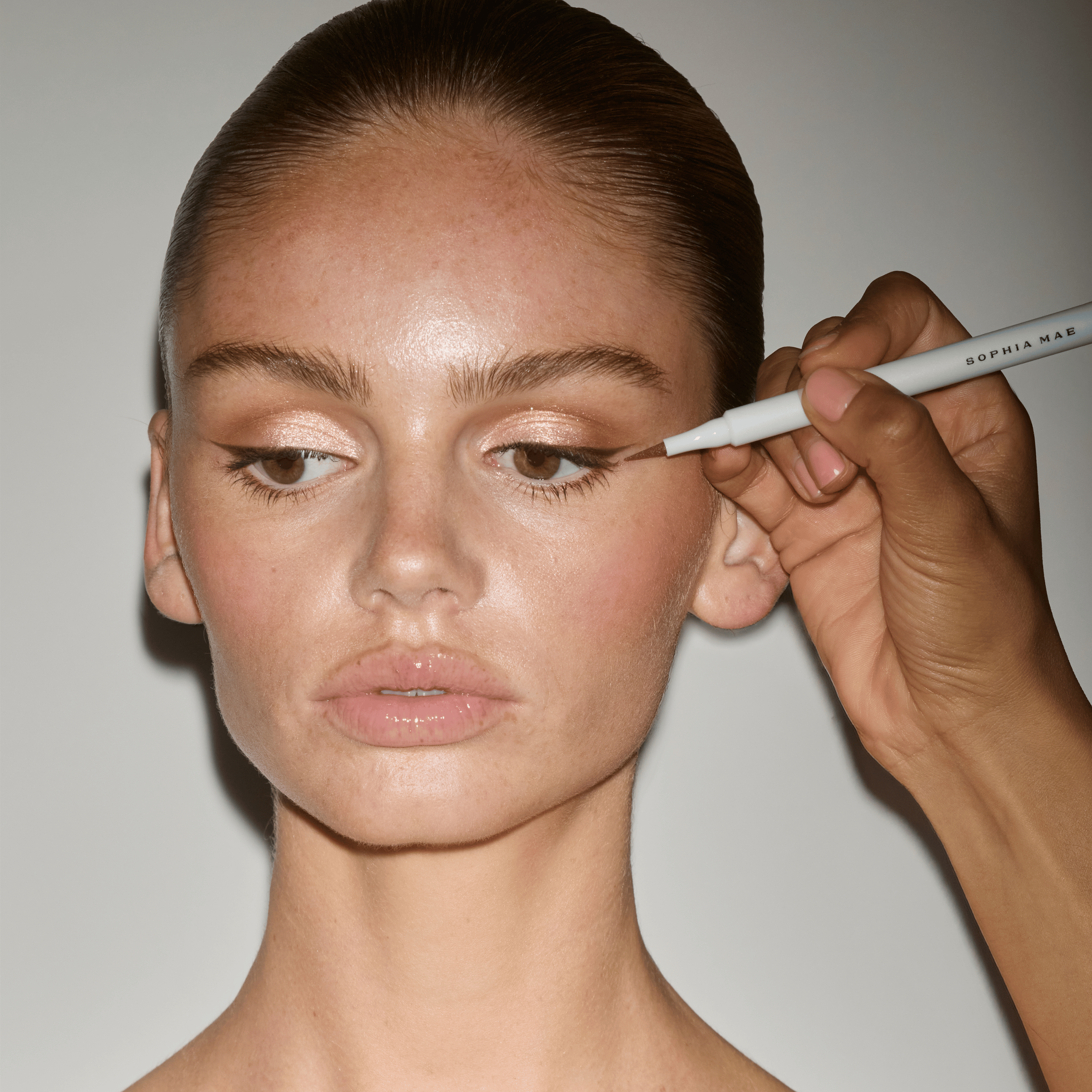 Liquid Eyeliner Coffee Bean applied along the upper lash line to create a soft, elongated brown wing.