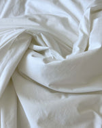 Clean white linen sheets freshly washed with the new Dew of dawn laundry perfume by SOPHIA MAE.