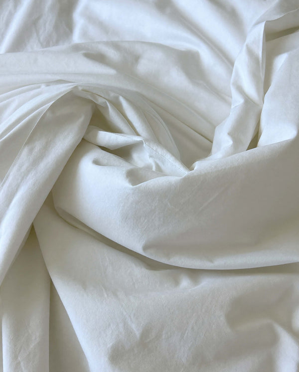 Clean white linen sheets freshly washed with the new Dew of dawn laundry perfume by SOPHIA MAE.
