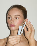 Model holding SOPHIA MAE Lip Liner and Lip Glaze, showcasing the products together for a softly defined, glossy lip look.