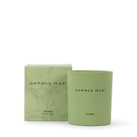 SOPHIA MAE Artemis scented candle in a soft green glass holder, displayed alongside its matching illustrated box packaging.