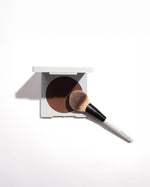 SOPHIA MAE Powder Brush resting on an open bronzer compact, ready for smooth and even application.