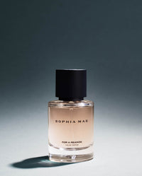 SOPHIA MAE For A Reason Eau de Parfum bottle photographed in moody studio lighting, with soft shadows that reflect the fragrance’s warm, mysterious character.