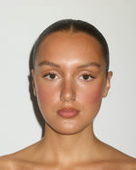 Model wearing a warm bronzed makeup look created with the SOPHIA MAE Powder Brush.