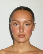 Model with a warm, sun-kissed complexion and softly flushed cheeks, showcasing the natural-looking glow of SOPHIA MAE Facial Tanning Mist.