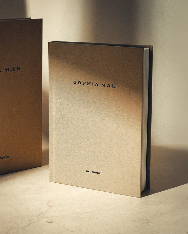 SOPHIA MAE notebook with beige linen cover in warm sunlight.
