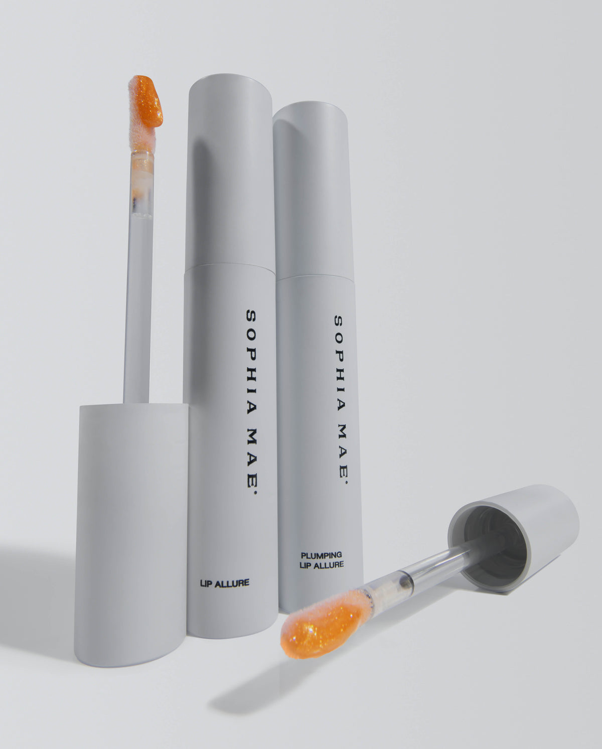 Product shot of SOPHIA MAE Plumping Lip Allure with tubes and applicators displayed on a light background.