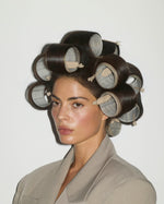 Model wearing large hair rollers secured with SOPHIA MAE creaseless hair clips.