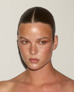 Frontal portrait of a model with a glowing complexion and subtle faux freckles applied using the SOPHIA MAE Freckle Pen.