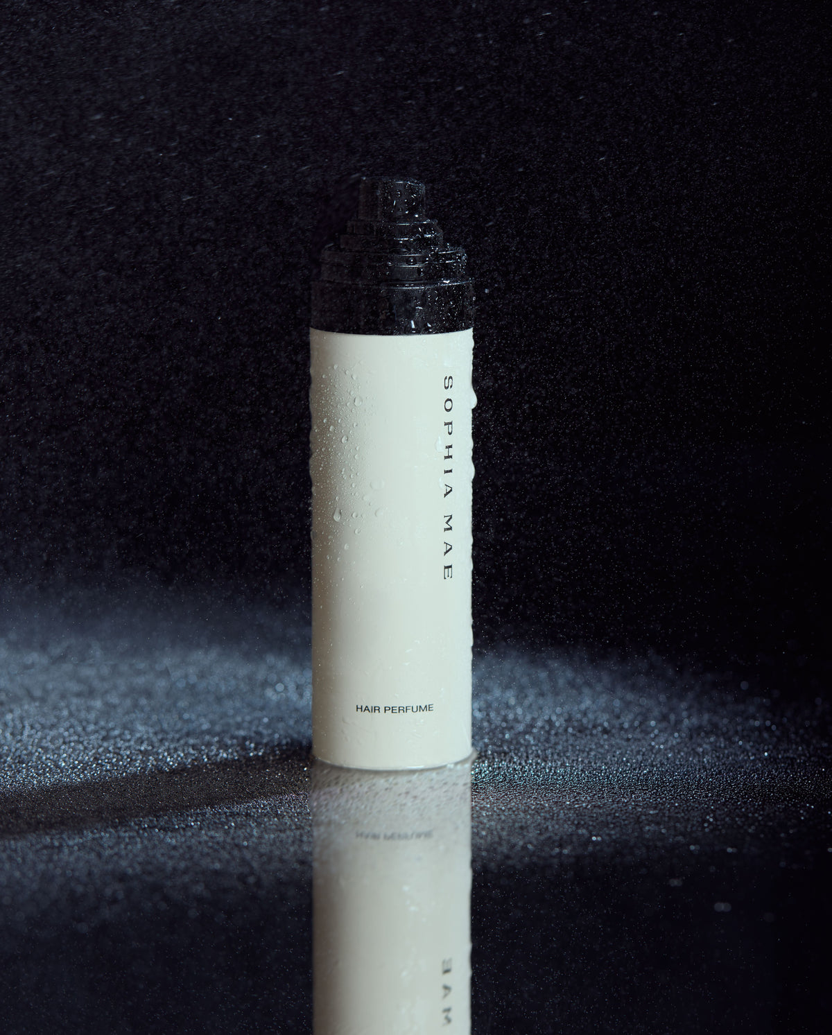 SOPHIA MAE Hair Perfume bottle with fine mist on a dark background.