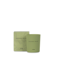 SOPHIA MAE Artemis scented candle in a soft green glass holder, displayed alongside its matching packaging.