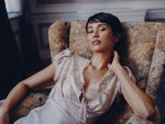 Eau de parfum sample Still in Bloom, campaign shoot SOPHIA MAE. Model laying on a vintage floral chair. 