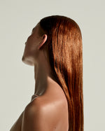 Side profile of a model with sleek, glossy hair showing the shine of SOPHIA MAE Nourishing Body & Hair Elixir.