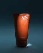 Orange tube of SOPHIA MAE Body Tanning Cream against a dark blue background.