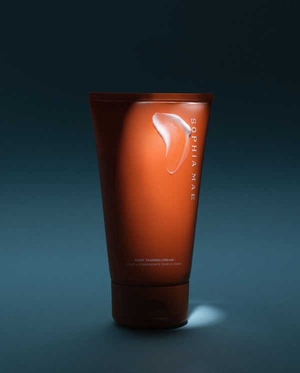 Orange tube of SOPHIA MAE Body Tanning Cream against a dark blue background.