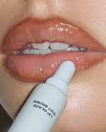 Close-up of SOPHIA MAE Lip Glaze in Soft Brown being applied directly to the lips, adding a warm tint with a glossy, high-shine finish.