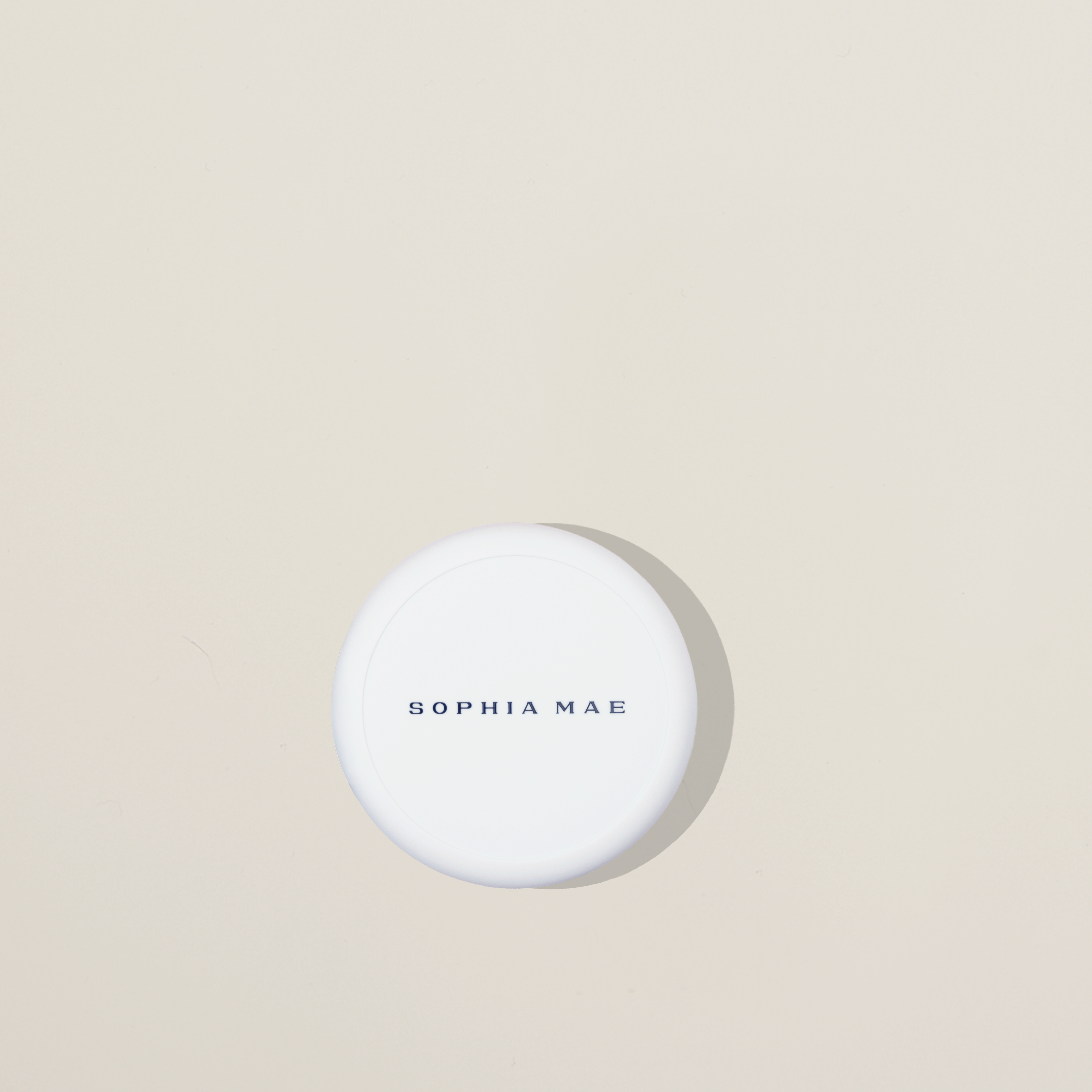 Tan Blusher: lightweight bronzed cream blush with a natural, tanned finish for cheeks, forehead, and lips. Packaging tan blusher on beige background. 