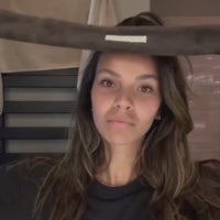 Woman wearing the brown SOPHIA MAE Headband while applying skincare to her face.