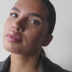 Video showcasing a finished makeup look with subtle brown winged eyeliner, softly shimmering eyelids and glossy pink lips.