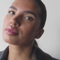 Video showcasing a finished makeup look with subtle brown winged eyeliner, softly shimmering eyelids and glossy pink lips.